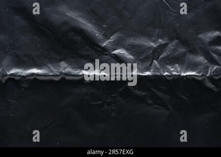Wrinkled black plastic bag texture, macro close up. Abstract background. Stock Photo
