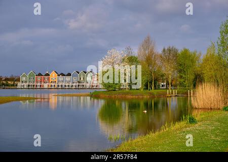 Houten, The Netherlands - April 25 2023. Trees and colourful wooden lakeside houses reflected in the water of lake De Rietplas. Stock Photo