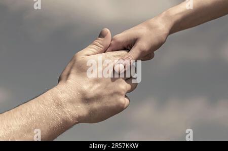 Lending a helping hand. Hands of man and woman reaching to each other, support. Solidarity, compassion, and charity, rescue. Giving a helping hand Stock Photo