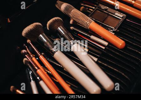 A set of different makeup artist brushes in a on black background Stock Photo