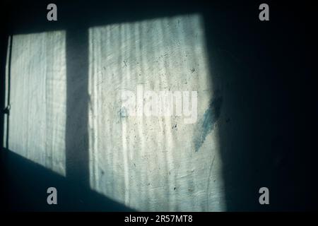 Light from window on wall. Light on blue wall. Interior details. Deep shadow from window. Stock Photo