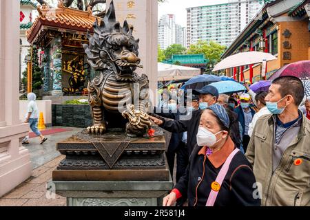 Chinese People Touching Statues For Good Luck At The Wong Tai Sin Temple, Hong Kong, China. Stock Photo