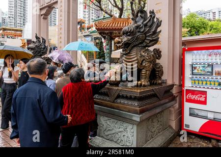 Chinese People Touching Statues For Good Luck At The Wong Tai Sin Temple, Hong Kong, China. Stock Photo