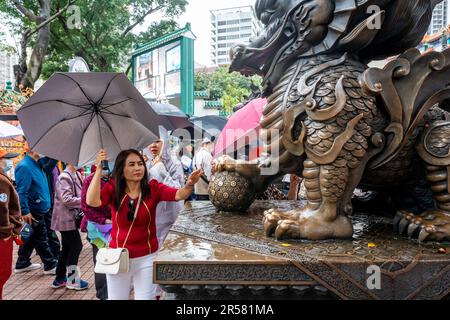 A Chinese Woman Touching A Statue For Good Luck At The Wong Tai Sin Temple, Hong Kong, China. Stock Photo