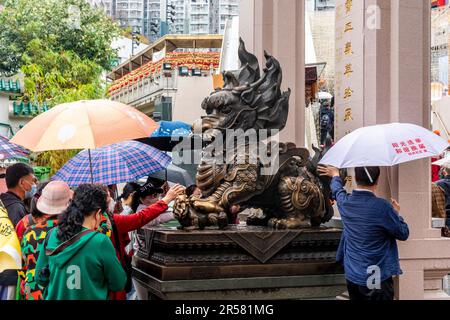 Chinese People Touching Statues For Good Luck At The Wong Tai Sin Temple, Hong Kong, China. Stock Photo