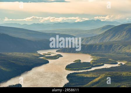 Expansive wilderness views along the Yukon River in Dawson City, Yukon Territory. Gold rush, mining area in arctic Canada at sunset with landscape. Stock Photo