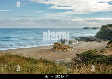 Rocky outcrops on a sandy beach in the Dunes of Liencres Natural Park, Cantabria, Spain Stock Photo
