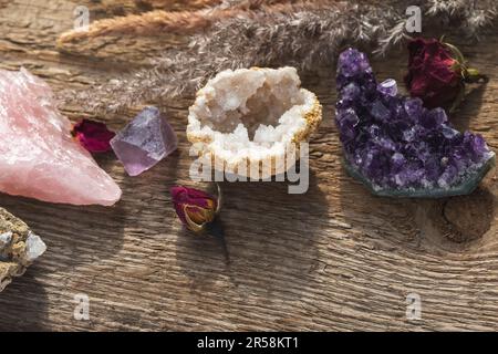 Alternative crystal healing concept. Healing Stones for Wicca Witchcraft Practice Set Up on Wooden Table with Dry Herbs and Flowers. Copy Space from t Stock Photo