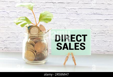 Business and finance concept. On a red background, gears and a thought plate with the inscription - DIRECT SALES Stock Photo
