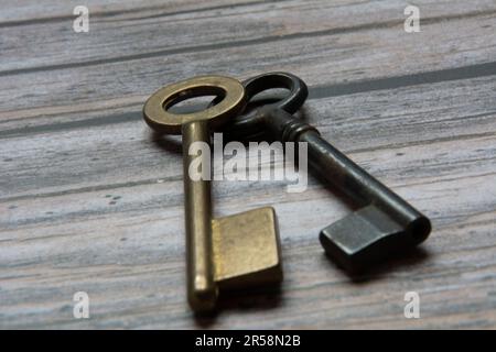 Old keys on iron and bronze, in a studio table. Wooden background. Stock Photo