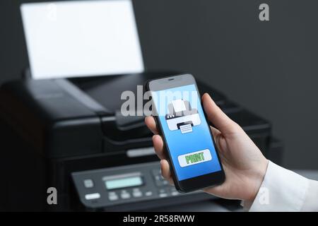 Man using printer management application on mobile phone indoors, closeup and space for text Stock Photo