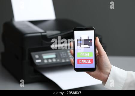 Man using printer management application on mobile phone indoors, closeup and space for text Stock Photo