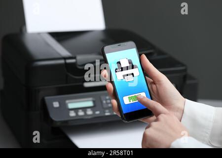 Man using printer management application on mobile phone indoors, closeup and space for text Stock Photo