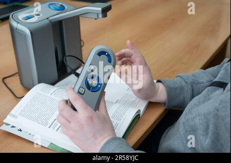 A visually impaired man uses a scanning and reading machine. Stock Photo