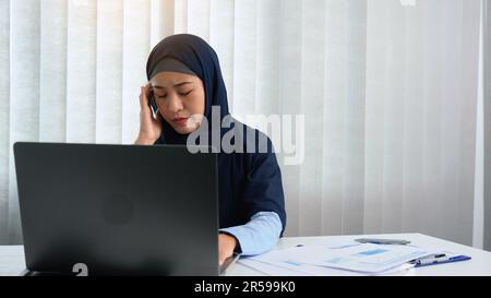 Muslim women sit at work stress and headache. Stock Photo