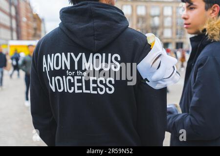 04.18.2023 Amsterdam, Netherlands. Protest on the streets of Amsterdam - anonymous for the voiceless - written on black hoodie of a young protester. High quality photo Stock Photo