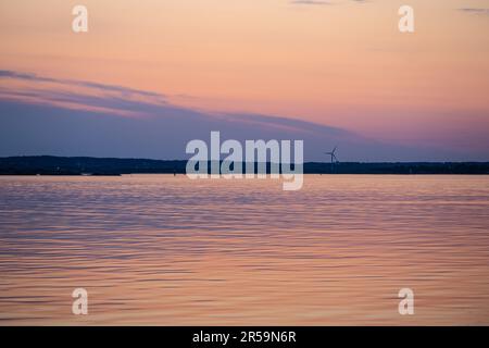 Evening light over a wind turbine by the sea Stock Photo