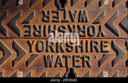 Close-up of a rusty cast iron utility grid embossed with the words “Yorkshire Water”, illustrating public water infrastructure and ageing metalwork Stock Photo