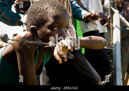 A young Kenyan boy listens to speeches by visiting dignitaries during the launch of a community-based HIV/AIDS program in Malaba, Kenya on Saturday, May 20, 2006. Stock Photo