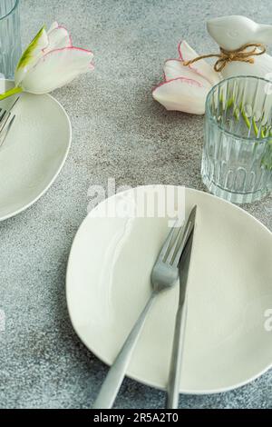 Table setting with seasonal flowers on concrete background Stock Photo