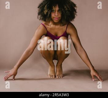 Multi racial female dancer looks at camera in dance pose Stock Photo