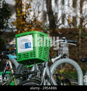 Strasbourg, France - Nov 22, 2022: A mode of transportation with a bike basket and Green commuting logotype of European parliament is ideal by bicycle. Stock Photo