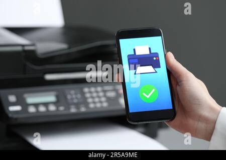 Man using printer management application on mobile phone indoors, closeup and space for text Stock Photo