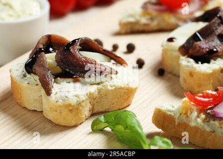 Delicious sandwiches with anchovies on wooden table, closeup Stock Photo