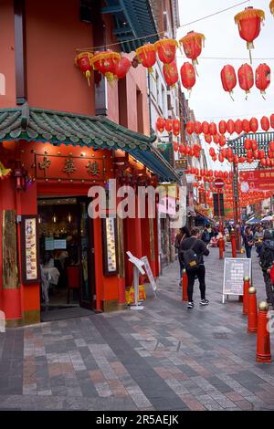 LONDON, United Kingdom - 27 April 2022: Crowds of people in Soho's China Town area of the West End with restaurants and other Chinese run businesses. Stock Photo
