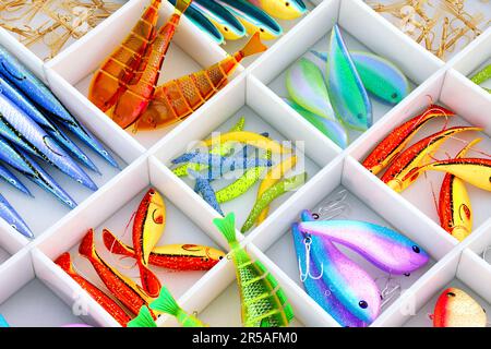 Assorted colorful fish baits. Fishing accessories in a box with compartments. Set of multicolor lures and fish hooks for the fishing hobby. Tackles. A Stock Photo