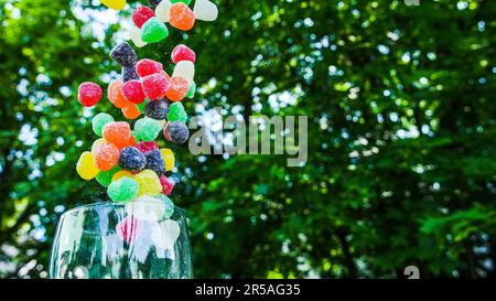 Colorful candy flying out from inside glass outdoor Stock Photo