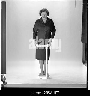 Woman in the 1960s. She is standing and weighs herself on a scale. Sweden november 1965 Stock Photo