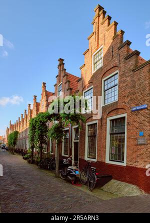 Haarlem, Netherlands - MAY 24, 2022: Row of houses with stepped gables in Groot Heiligland street in old town. Diminishing perpsective. Stock Photo