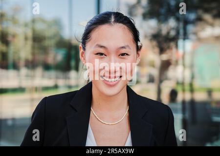 Individual close up portrait of one happy business woman looking at camera smiling with perfect white teeth wearing elegant suit. Young executive asian female or successful corporate office secretary. High quality photo Stock Photo
