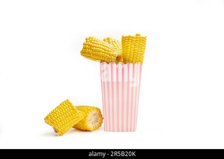 Pieces of corn in a pink and white striped bucket and on a white background with copy space Stock Photo