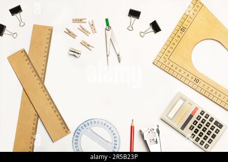 Wooden triangle ruler, compass, rullers and a calculator on a white background with copy space Stock Photo