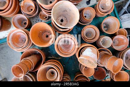 Flower pots; random piles and stacks of vintage terracotta flowerpots. Top down view. Stock Photo