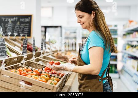 Happy woman working inside grocery store Stock Photo