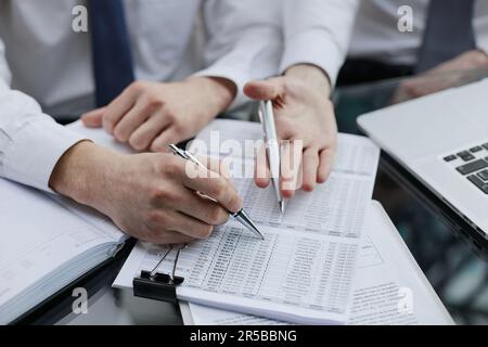 Close up of two office worker hands analyzing a growth graph on a desktop Stock Photo