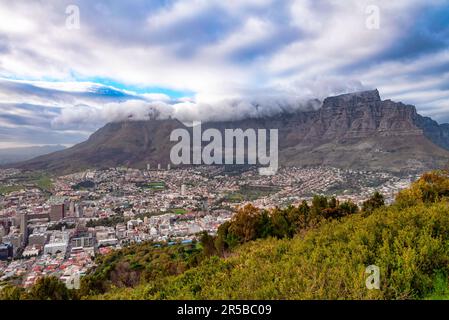 The Table Mountain Covered by Tablecloth in Cape Town, South Africa. It is a flat-topped mountain forming a prominent landmark overlooking the city Stock Photo