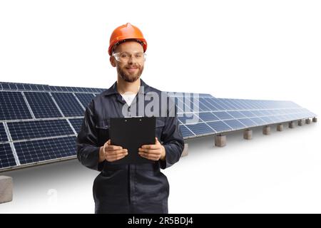 Technician in a uniform with a helmet and goggles holding a clipboard at a photovoltaic field isolated on white background Stock Photo