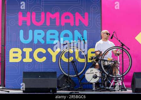 Puncture Kit, the bicycle drummer, playing at the RideLondon cycle event in Trafalgar Square, London, UK. Musician Stock Photo