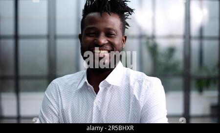 Confident young smiling businessman in shirt posing at camera Stock Photo