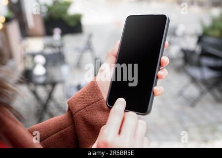 Cropped image of woman's hand holding smart phone with blank copy space screen for your text message or promotional content Stock Photo