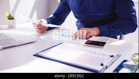 Business Accountant Using Finance Chart Document And Calculator Stock Photo