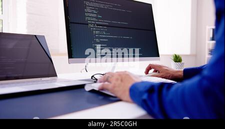 Computer Programmer Writing Program Code On Computer In Office Stock Photo