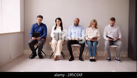 Unemployed Job Applicants Waiting In Line in Office Stock Photo