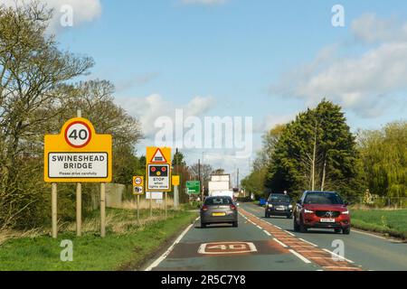 Traffic approaching railway level crossing at Swineshead bridge on the A17.  View is to the north. Stock Photo