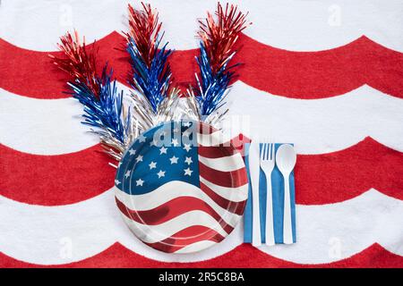 Red, white and blue paper plate picnic setting on red and white background for Fourth of July Stock Photo