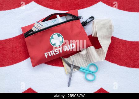 First aid medical kit and supplies on red and white background. Stock Photo